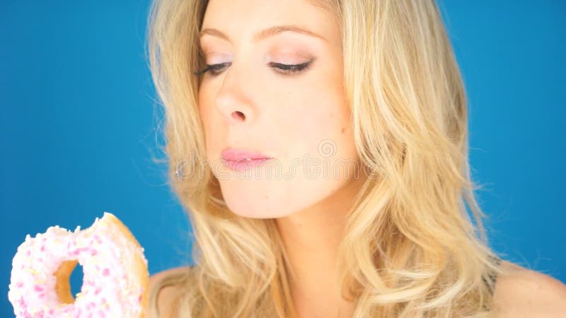 Belle femme savouring un beignet clips vidéos