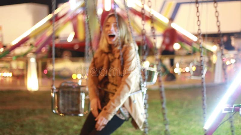 Belle femme sur l'oscillation en parc d'attractions