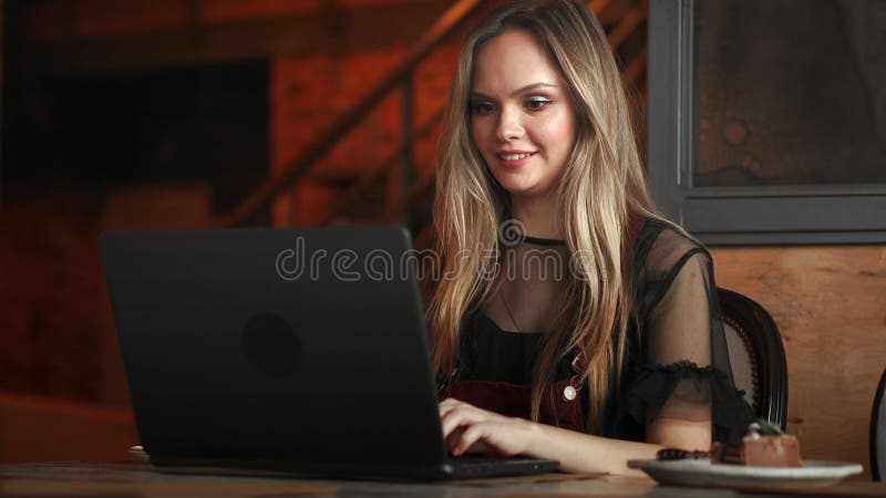 Belle femme travaillant sur son ordinateur portable sur un restaurant urbain élégant