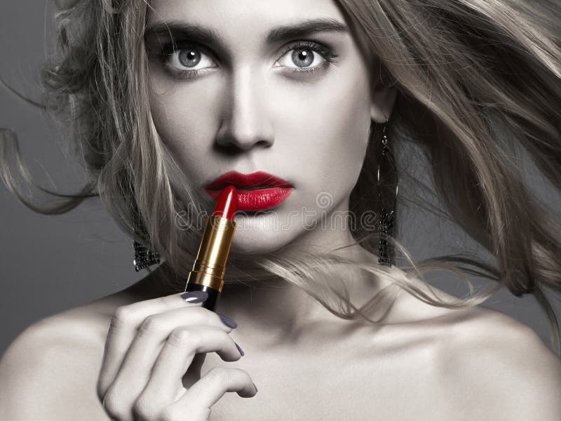 Belle fille appliquant le rouge à lèvres jeune femme mettant le rouge à lèvres rouge photos stock Belle fille appliquant le rouge à lèvres jeune femme mettant le rouge à lèvres rouge photos stock