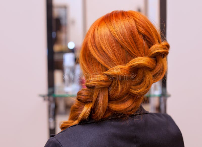 Belle fille avec de longs cheveux rouges, tressés avec une tresse française, dans un salon de beauté photos stock Belle fille avec de longs cheveux rouges, tressés avec une tresse française, dans un salon de beauté photos stock