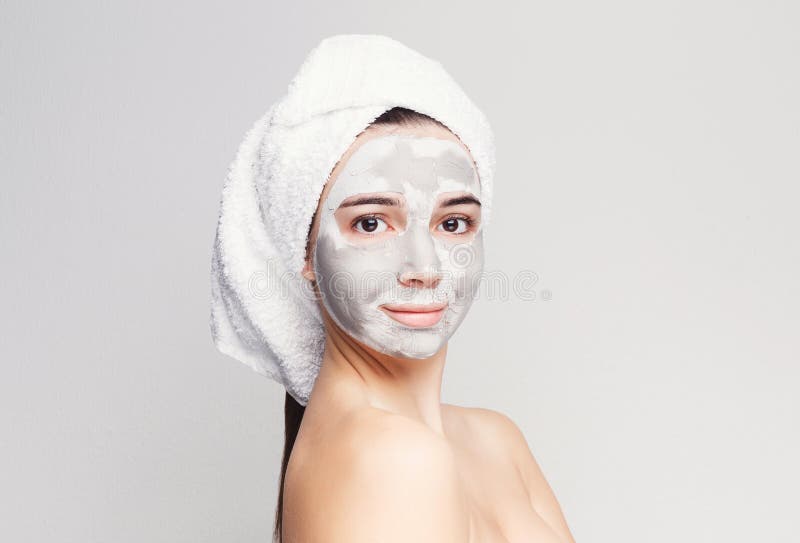 Belle fille avec le masque appliqué d'argile au fond blanc images libres de droits Belle fille avec le masque appliqué d'argile au fond blanc images libres de droits