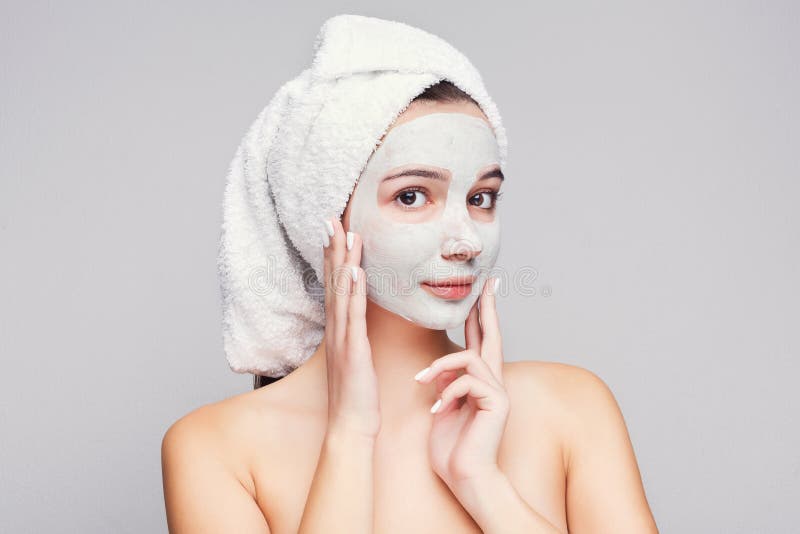 Belle fille avec le masque appliqué d'argile au fond blanc photo stock Belle fille avec le masque appliqué d'argile au fond blanc photo stock