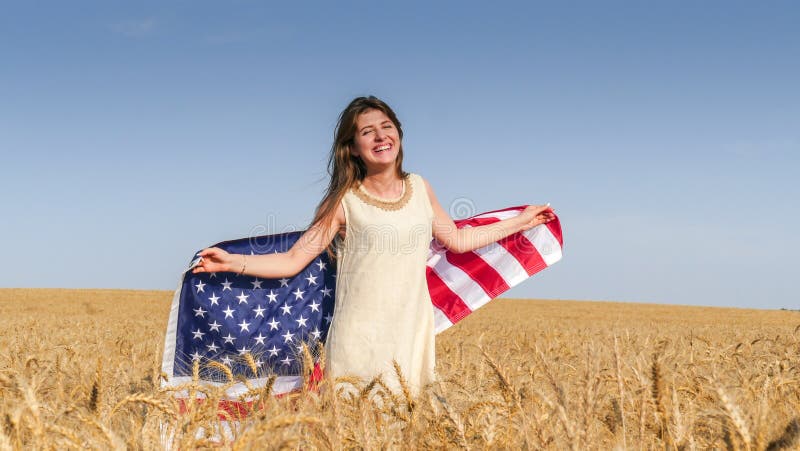 Belle fille avec un drapeau des USA dans le domaine photos stock Belle fille avec un drapeau des USA dans le domaine photos stock