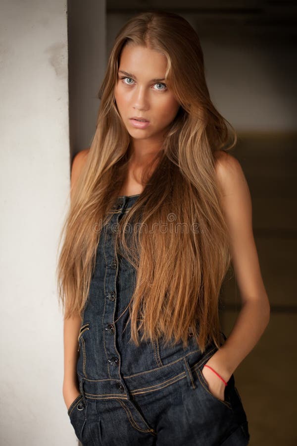 Belle fille blonde sexy mince dans des jeans combinés photos stock
