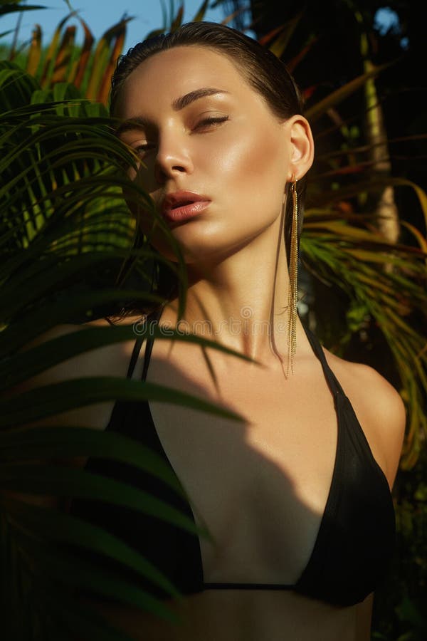Belle fille d'été au coucher du soleil. jeune femme sexy en bikini sous palmier photo stock