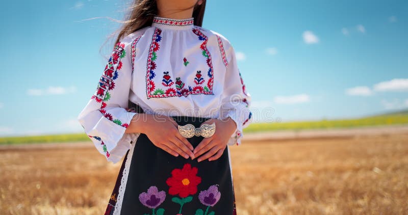 Belle fille dans le traditionnel costume de folklore bulgare avec broderie bulgare et boucles de ceinture sur le champ de blé clips vidéos