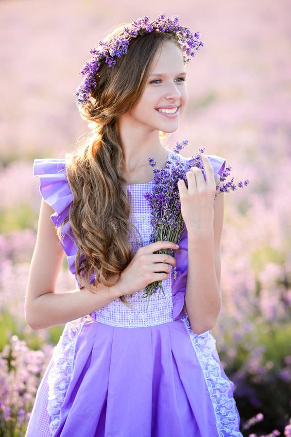 Belle fille dans un domaine de lavande sur le coucher du soleil photos stock Belle fille dans un domaine de lavande sur le coucher du soleil photos stock