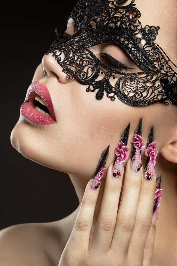 Belle fille dans un masque avec de longs ongles photographie stock libre de droits Belle fille dans un masque avec de longs ongles photographie stock libre de droits