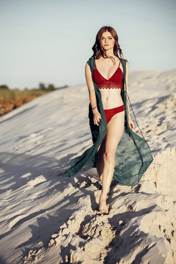 Belle fille de boho dans le maillot de bain rouge marchant sur la plage sablonneuse au su photos libres de droits Belle fille de boho dans le maillot de bain rouge marchant sur la plage sablonneuse au su photos libres de droits