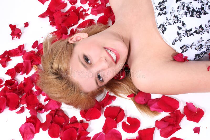 Belle fille de l'adolescence s'étendant sur le pétale de Rose au-dessus du blanc photos stock Belle fille de l'adolescence s'étendant sur le pétale de Rose au-dessus du blanc photos stock