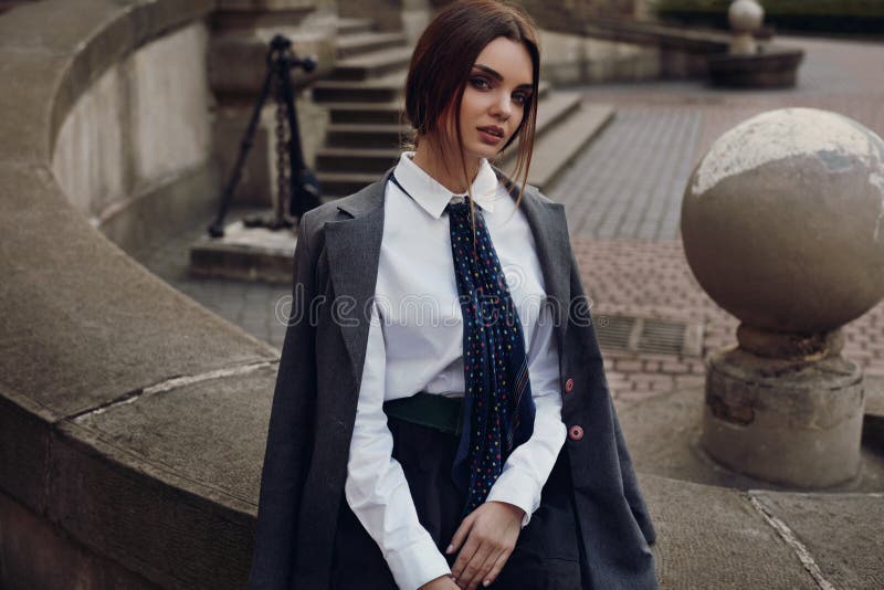 Belle fille de mode dans l'habillement à la mode posant dans la rue photographie stock Belle fille de mode dans l'habillement à la mode posant dans la rue photographie stock