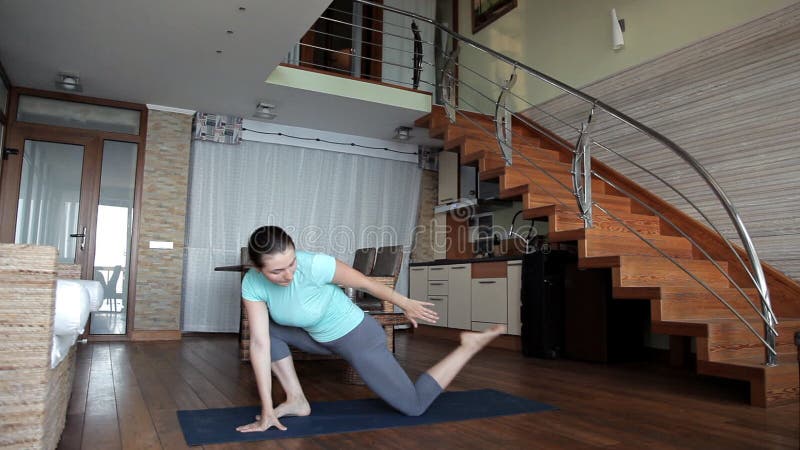 Belle fille de sports occupée dans la forme physique à la maison, s'étendant banque de vidéos