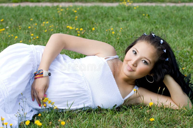 Belle fille enceinte se trouvant sur l'herbe photographie stock libre de droits