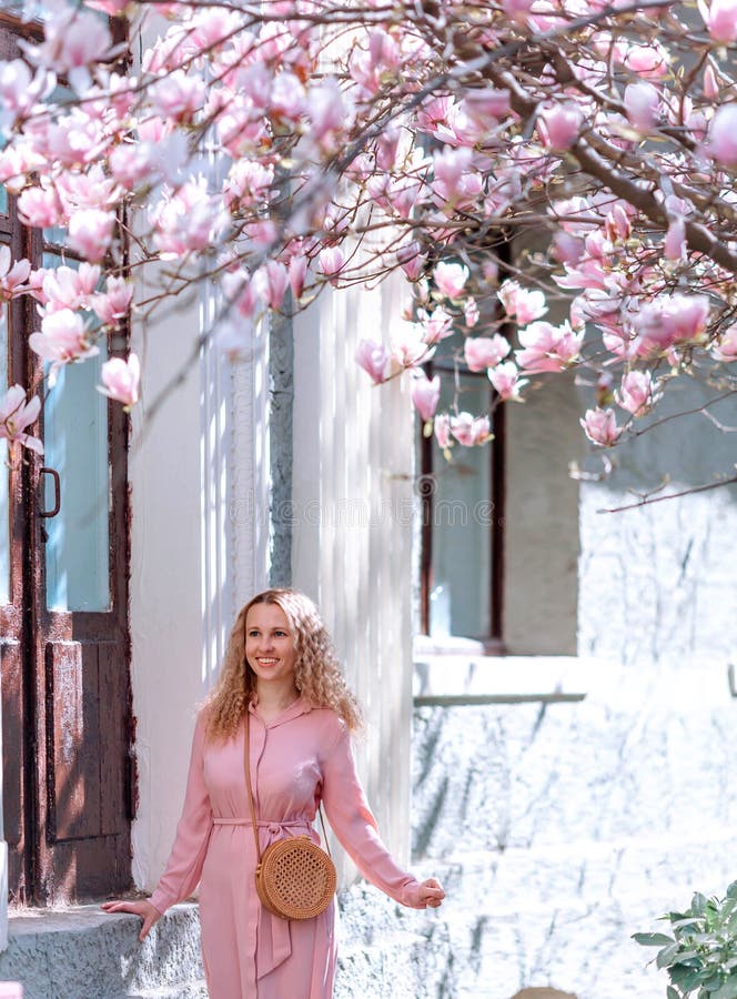 Belle fille romantique de ressort dans la position de robe de mode dans les arbres de floraison de magnolia photographie stock Belle fille romantique de ressort dans la position de robe de mode dans les arbres de floraison de magnolia photographie stock