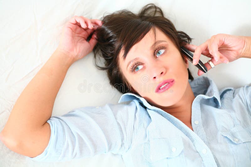 Belle fille se trouvant vers le bas parlant sur la cellule photographie stock libre de droits Belle fille se trouvant vers le bas parlant sur la cellule photographie stock libre de droits