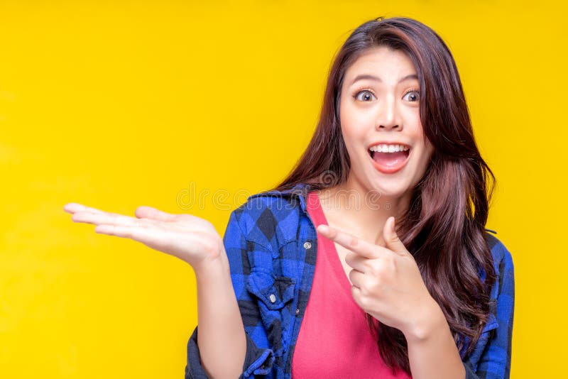 Belle jeune femme asiatique dirigeant le doigt pour copier l'espace Beau produit attrayant d'exposition de fille qui font son sat photographie stock libre de droits Belle jeune femme asiatique dirigeant le doigt pour copier l'espace Beau produit attrayant d'exposition de fille qui font son sat photographie stock libre de droits