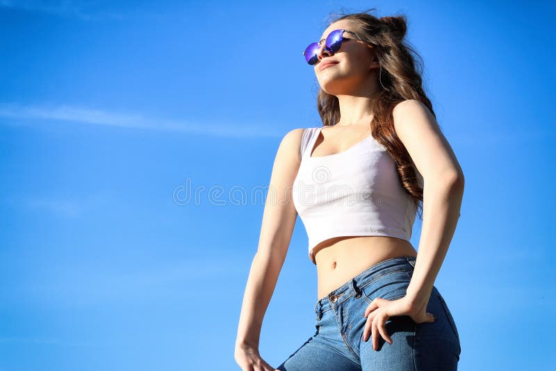 Belle jeune femme au-dessus de ciel bleu photo stock Belle jeune femme au-dessus de ciel bleu photo stock