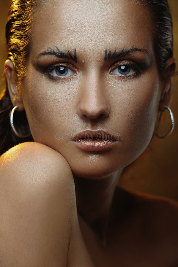Belle jeune femme avec le renivellement d'or et la peau de bronze photo stock Belle jeune femme avec le renivellement d'or et la peau de bronze photo stock