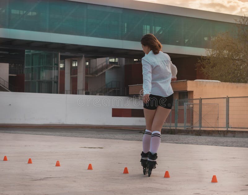 Belle jeune femme ayant l'amusement avec des patins de rouleau image libre de droits Belle jeune femme ayant l'amusement avec des patins de rouleau image libre de droits