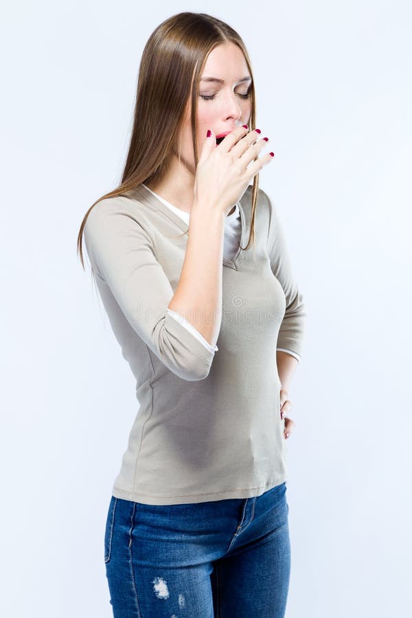 Belle jeune femme baîllant au-dessus du fond blanc photographie stock Belle jeune femme baîllant au-dessus du fond blanc photographie stock