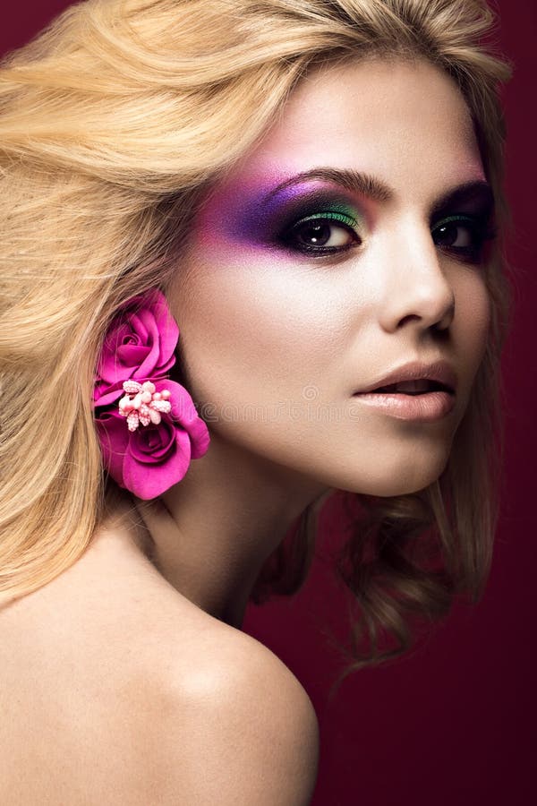 Belle jeune femme blonde avec la couleur créative de maquillage et fleurs sur les oreilles Visage de beauté Art Makeup image stock Belle jeune femme blonde avec la couleur créative de maquillage et fleurs sur les oreilles Visage de beauté Art Makeup image stock