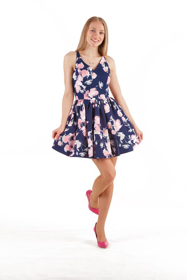 Belle jeune femme blonde dans la robe bleu-fonc? avec l'impression florale d'isolement sur le fond blanc photos stock Belle jeune femme blonde dans la robe bleu-fonc? avec l'impression florale d'isolement sur le fond blanc photos stock