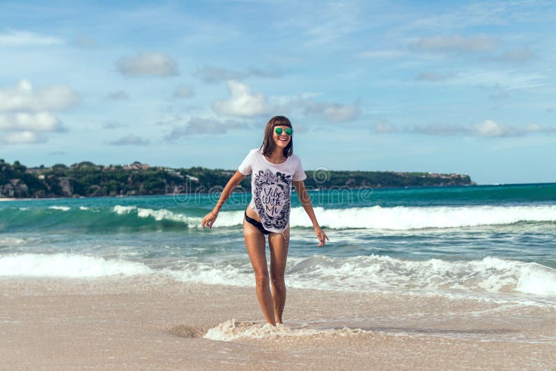 Belle jeune femme dans des lunettes de soleil posant sur la plage d'une île tropicale de Bali, Indonésie