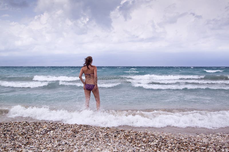 Belle jeune femme dans le bikini sur la plage images libres de droits Belle jeune femme dans le bikini sur la plage images libres de droits