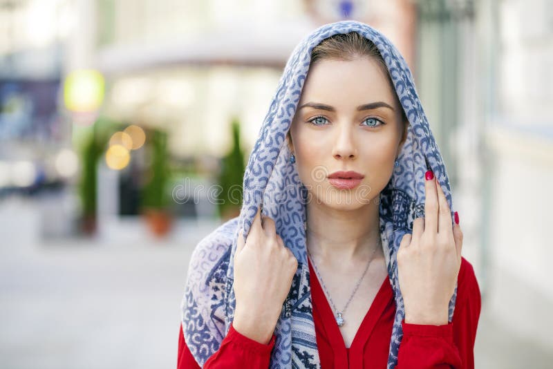 Belle jeune femme dans une écharpe bleue sur la ville de rue d'été photo libre de droits Belle jeune femme dans une écharpe bleue sur la ville de rue d'été photo libre de droits