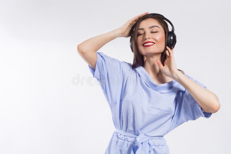 Belle jeune femme de sourire écoutant la musique au-dessus du fond blanc Mode de vie et concept de personnes photo libre de droits Belle jeune femme de sourire écoutant la musique au-dessus du fond blanc Mode de vie et concept de personnes photo libre de droits