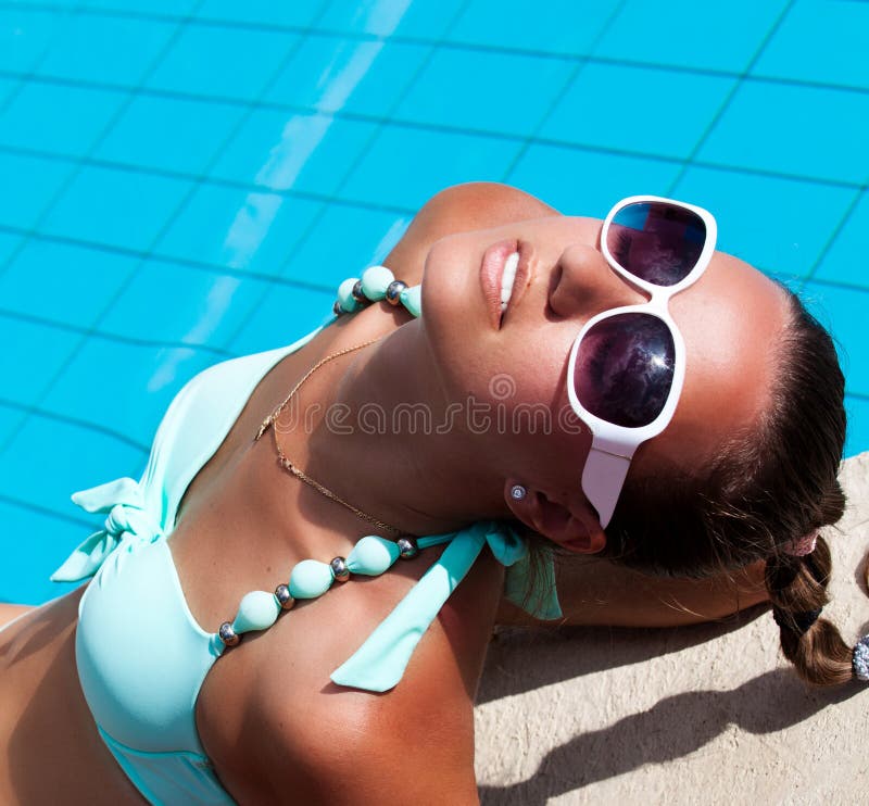 Belle jeune femme détendant près de la piscine photos libres de droits Belle jeune femme détendant près de la piscine photos libres de droits