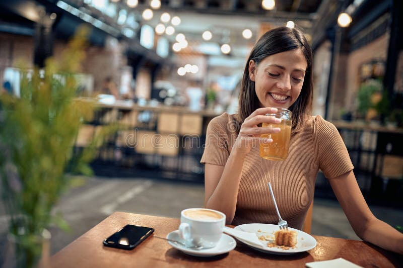 Belle jeune femme en jus d'orange. femme au coffee shop images libres de droits