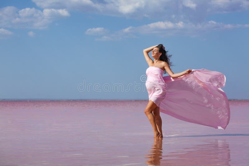 Belle jeune femme enceinte appréciant le soleil sur la plage, lac rose image stock Belle jeune femme enceinte appréciant le soleil sur la plage, lac rose image stock