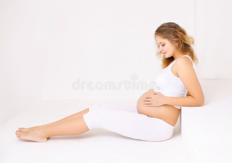 Belle jeune femme enceinte se trouvant à la maison photo libre de droits Belle jeune femme enceinte se trouvant à la maison photo libre de droits