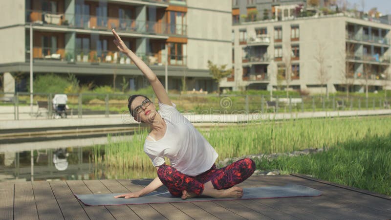 Belle jeune femme faisant le yoga dehors près de la maison