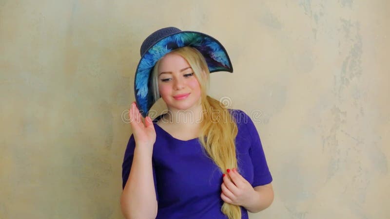 Belle jeune femme pose en gros chapeau bleu dans banque de vidéos