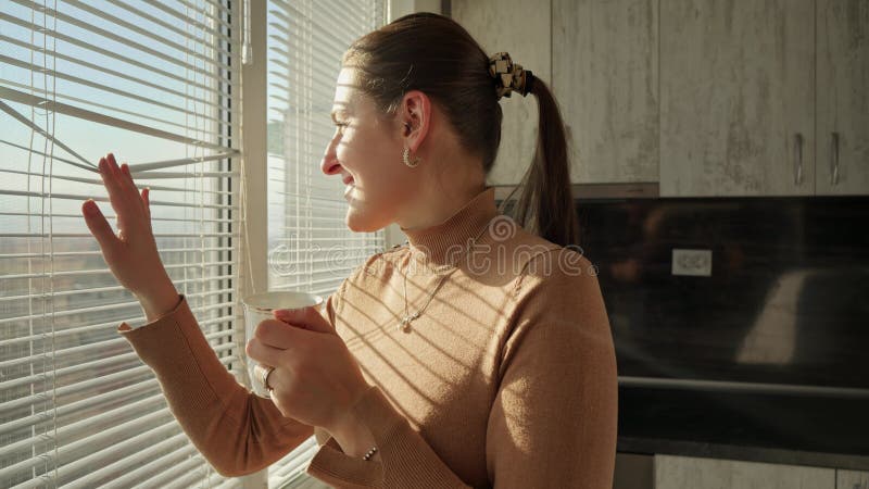 Belle jeune femme qui boit du café le matin et regarde la vue sur la ville. gens le matin beau paysage urbain.