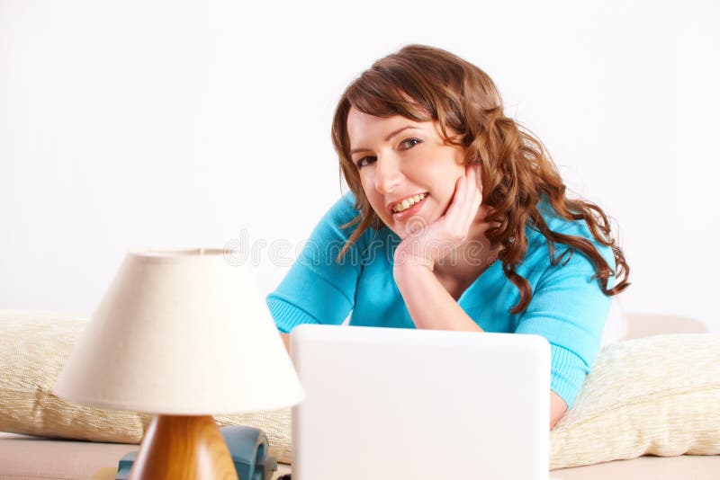 Belle jeune femme s'étendant sur le sofa photographie stock libre de droits Belle jeune femme s'étendant sur le sofa photographie stock libre de droits