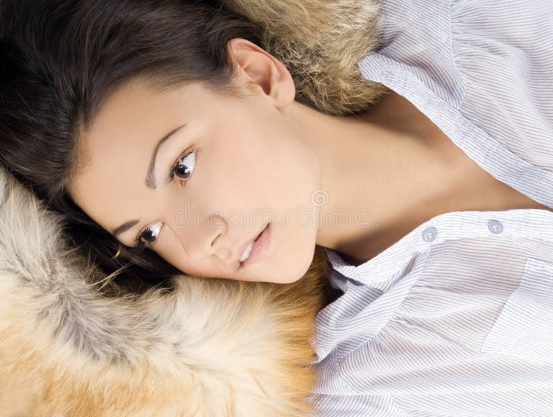 Belle jeune femme se situant dans une fourrure photographie stock libre de droits Belle jeune femme se situant dans une fourrure photographie stock libre de droits