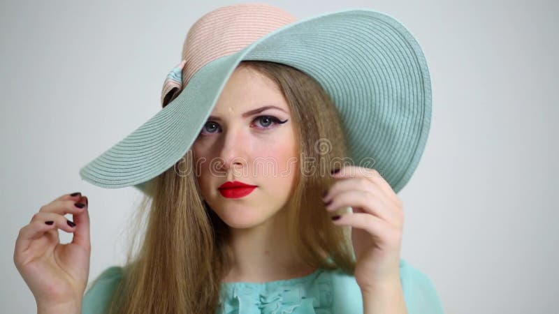 Belle jeune femme sourit en grand cyan chapeau clips vidéos