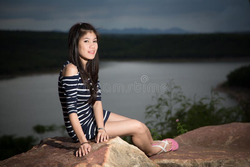 Belle jeune fille avec le fond de rivière et de ciel photographie stock libre de droits Belle jeune fille avec le fond de rivière et de ciel photographie stock libre de droits