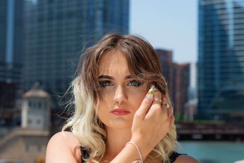 Belle jeune fille caucasienne avec le nez Ring Horseshoe Nose Ring de septum de Barbell en Windy City à un jour ensoleillé image libre de droits Belle jeune fille caucasienne avec le nez Ring Horseshoe Nose Ring de septum de Barbell en Windy City à un jour ensoleillé image libre de droits