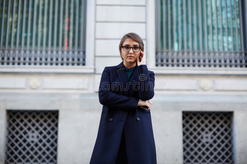 Belle jeune fille de brune avec de longs cheveux se tenant près d'un beau bâtiment photos libres de droits Belle jeune fille de brune avec de longs cheveux se tenant près d'un beau bâtiment photos libres de droits