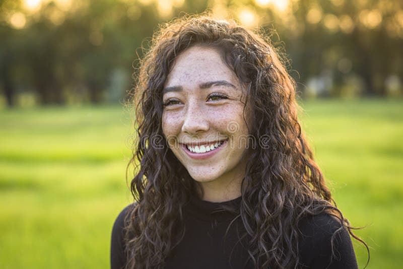 Belle jeune fille de l'adolescence hispanique riante et de sourire dehors images stock