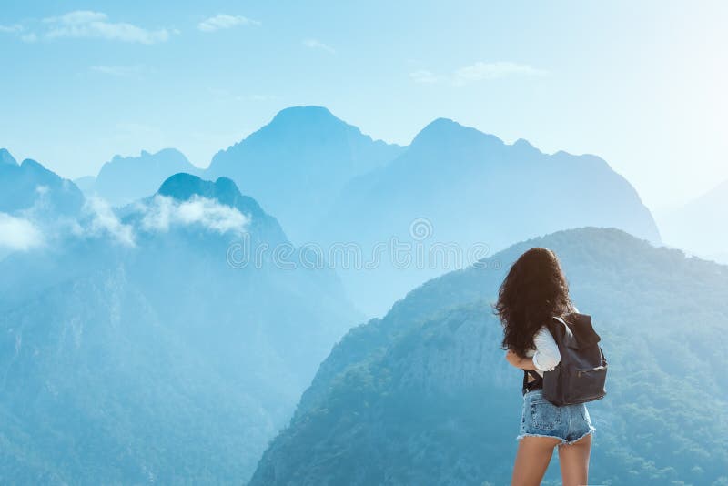 Belle jeune fille de touristes avec le sac à dos aux montagnes photographie stock libre de droits Belle jeune fille de touristes avec le sac à dos aux montagnes photographie stock libre de droits