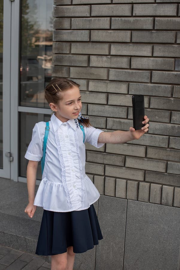 Belle jeune fille souriante en train de prendre un selfie à l'extérieur Enfant prenant l'auto-portrait avec son téléphone portabl images stock