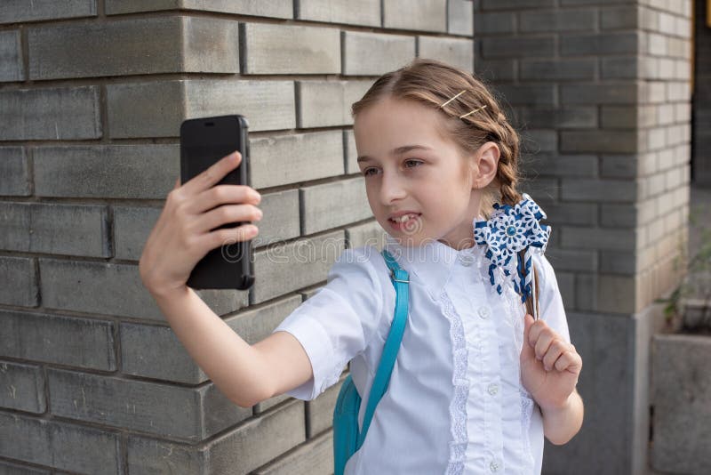Belle jeune fille souriante en train de prendre un selfie à l'extérieur Enfant prenant l'auto-portrait avec son téléphone portabl photographie stock
