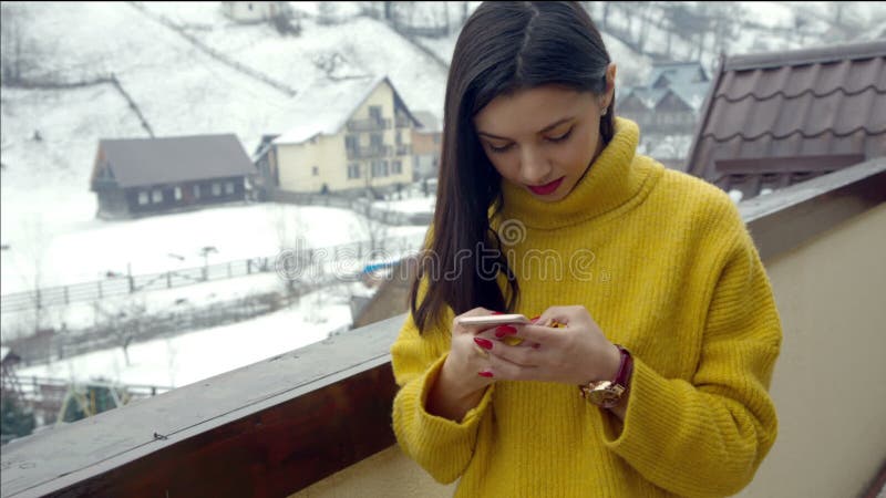 Belle jeune fille écrivant un message textuel au téléphone