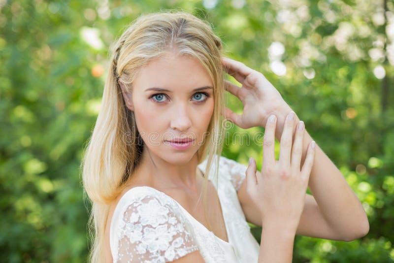 Belle jeune mariée heureuse touchant ses cheveux photographie stock libre de droits Belle jeune mariée heureuse touchant ses cheveux photographie stock libre de droits